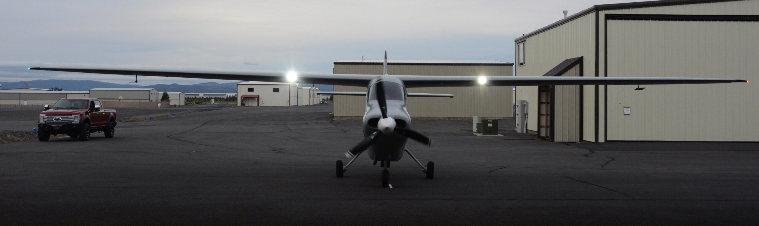 NightHawk QS3 quiet surveillance aircraft parked on the ramp in front of its hangar